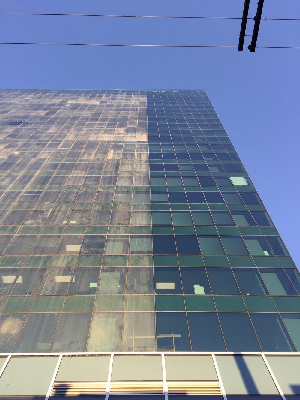 Commercial building with glass façade showing before-and-after exterior cleaning results